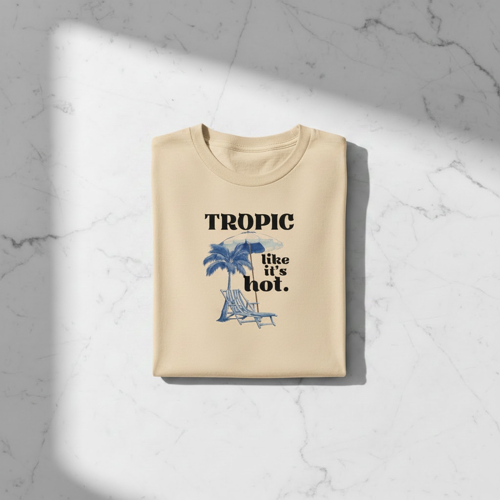 Natural/beige tropical graphic T-shirt with palm, umbrella, and “like it’s hot” print