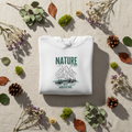 White hoodie with green nature, mountain, and “Best Medicine” graphic, front view.