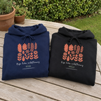 Navy and black Wildflowers hoodies folded together in a garden