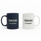 Two coffee mugs: navy and white, each with THRIVING (Term dependant) text