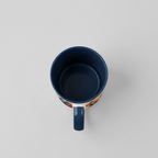 Top view of printed ceramic tea mug with dark blue interior and handle