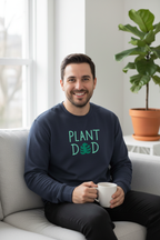 Navy crewneck sweatshirt worn by a man holding a mug, “PLANT DED” graphic