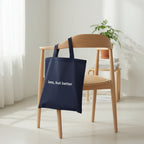 Navy blue cotton tote bag with long handles and 'less, but better' front print.