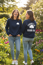 Navy sweatshirt with white tree and “BLOOM ERA” graphic