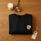 Black crewneck sweatshirt featuring a small embroidered cupcake detail
