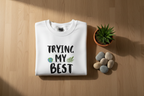 White crewneck sweatshirt with 'TRYING MY BEST' front graphic, long sleeves