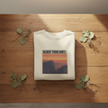 White crewneck sweatshirt with “OLDER THAN DIRT.” graphic