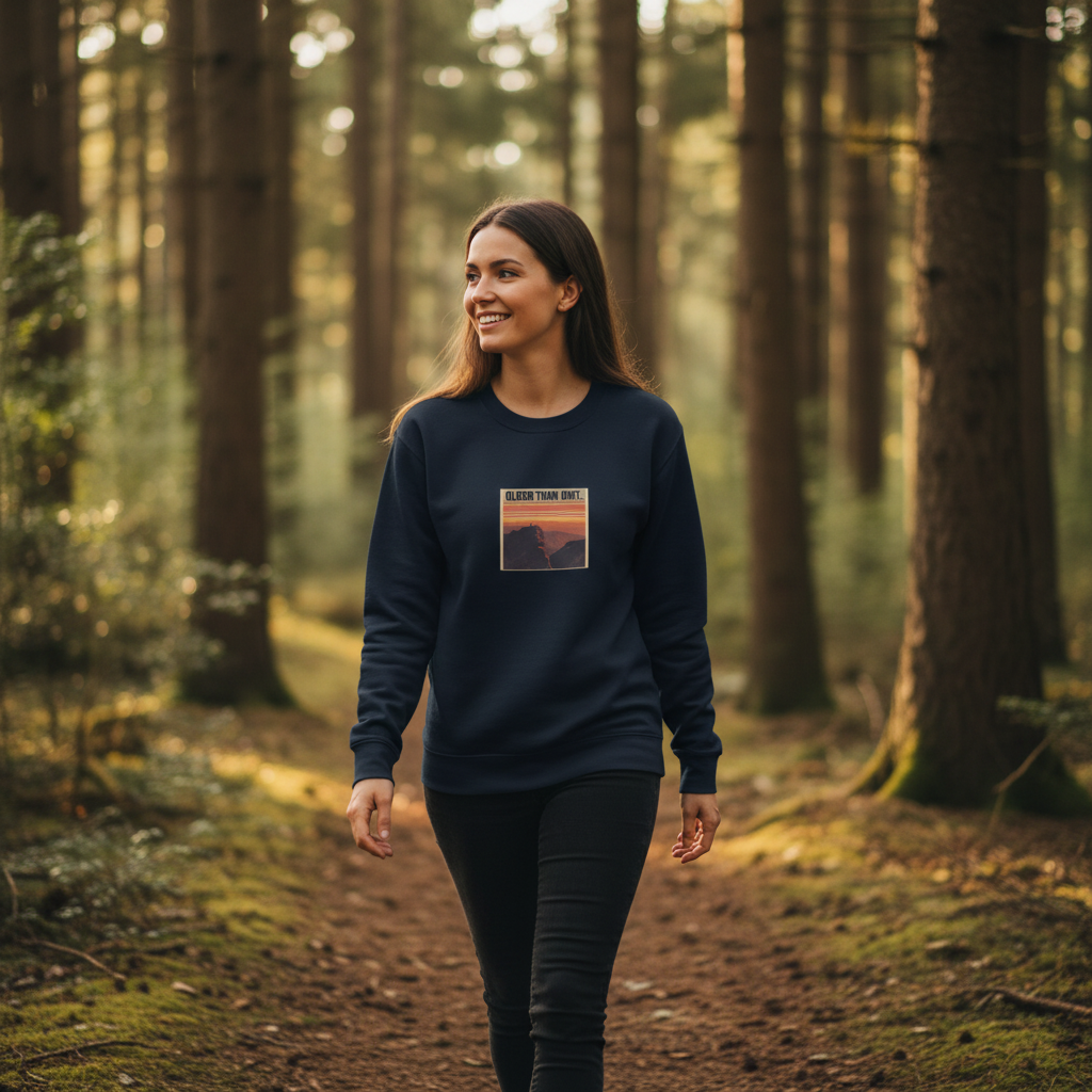 Navy crewneck sweatshirt with “OLDER THAN DIRT.” graphic, worn by woman outdoors