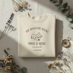 Arctic white sweatshirt with 'Our Adventure Begins' mountain print and names Maya & Noah