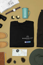 Black crewneck sweatshirt with Wanderlust is calling graphic and small logo patch