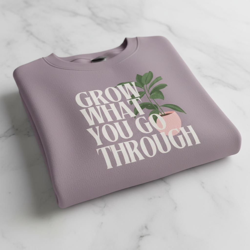 Mauve sweatshirt close-up with “Grow What You Go Through” slogan and green plant graphic