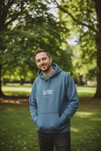 Man wearing a navy pullover hoodie with front pocket, hood drawstrings, and chest logo.