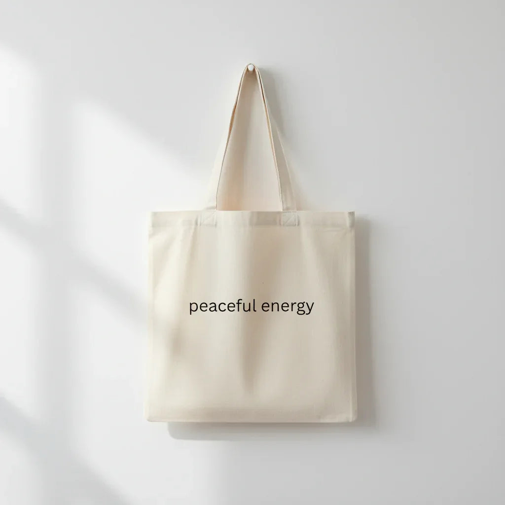 Cream cotton tote bag with long handles and 'peaceful energy' front print.