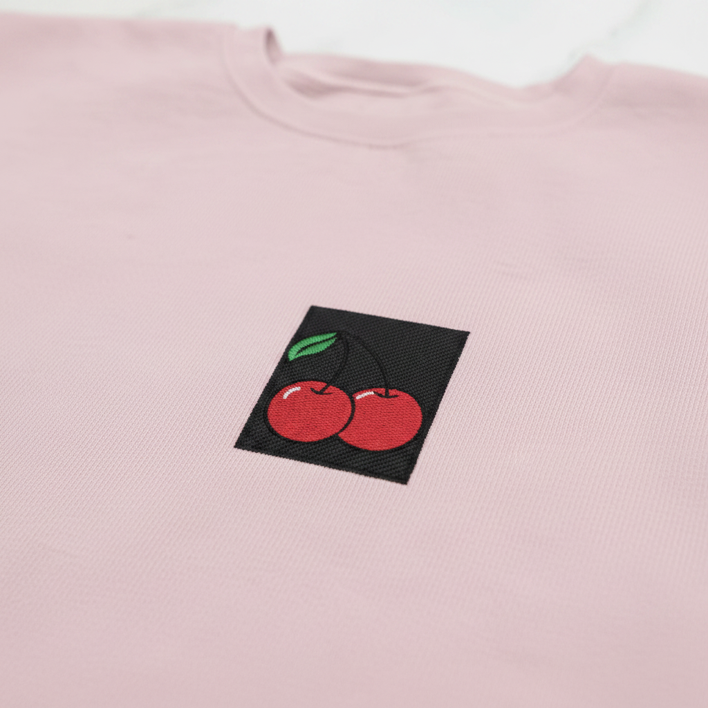 Light pink cherry embroidered sweatshirt close-up of chest cherry patch