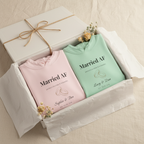 Couples hoodie set in mint green and light pink, each with printed “Married AF” on chest