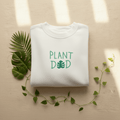 Arctic white crewneck sweatshirt with Plant Dad graphic on the front, long sleeves