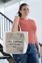 Canvas tote bag with bold “Overthinking Everything” graphic print and wide handles