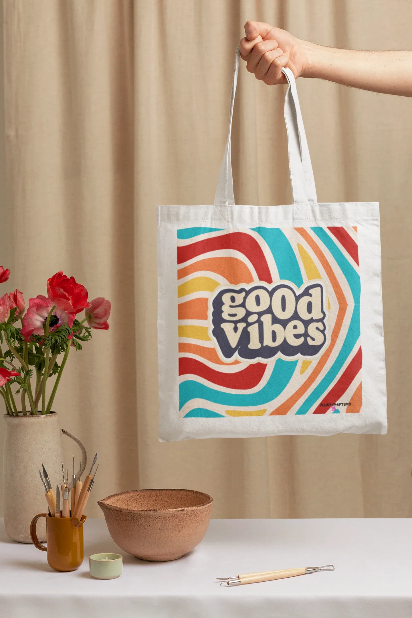 White tote bag with “good vibes” logo and colorful rainbow wave stripes
