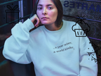 White crewneck sweatshirt with "a year wiser, a world kinder" text print