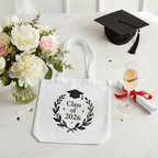 White graduation tote bag with 'Class of 2026' wreath and cap emblem