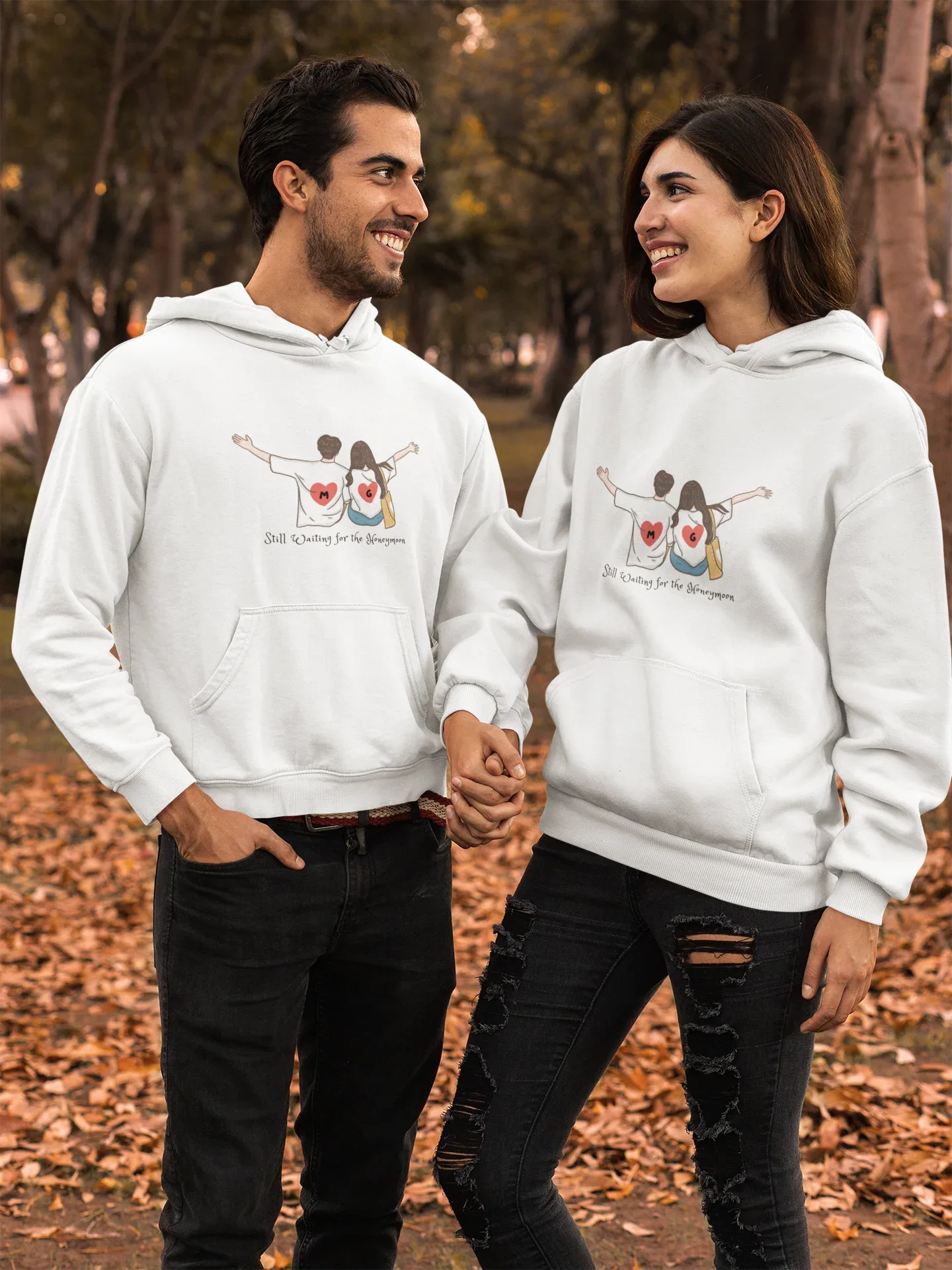 White hoodie with couple heart graphic on chest, worn by two people.