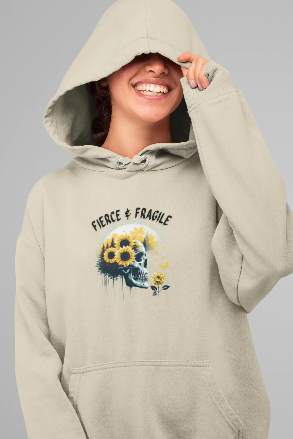 Light cream hooded sweatshirt with front graphic skull and flower design, drawstring hood and pocket.