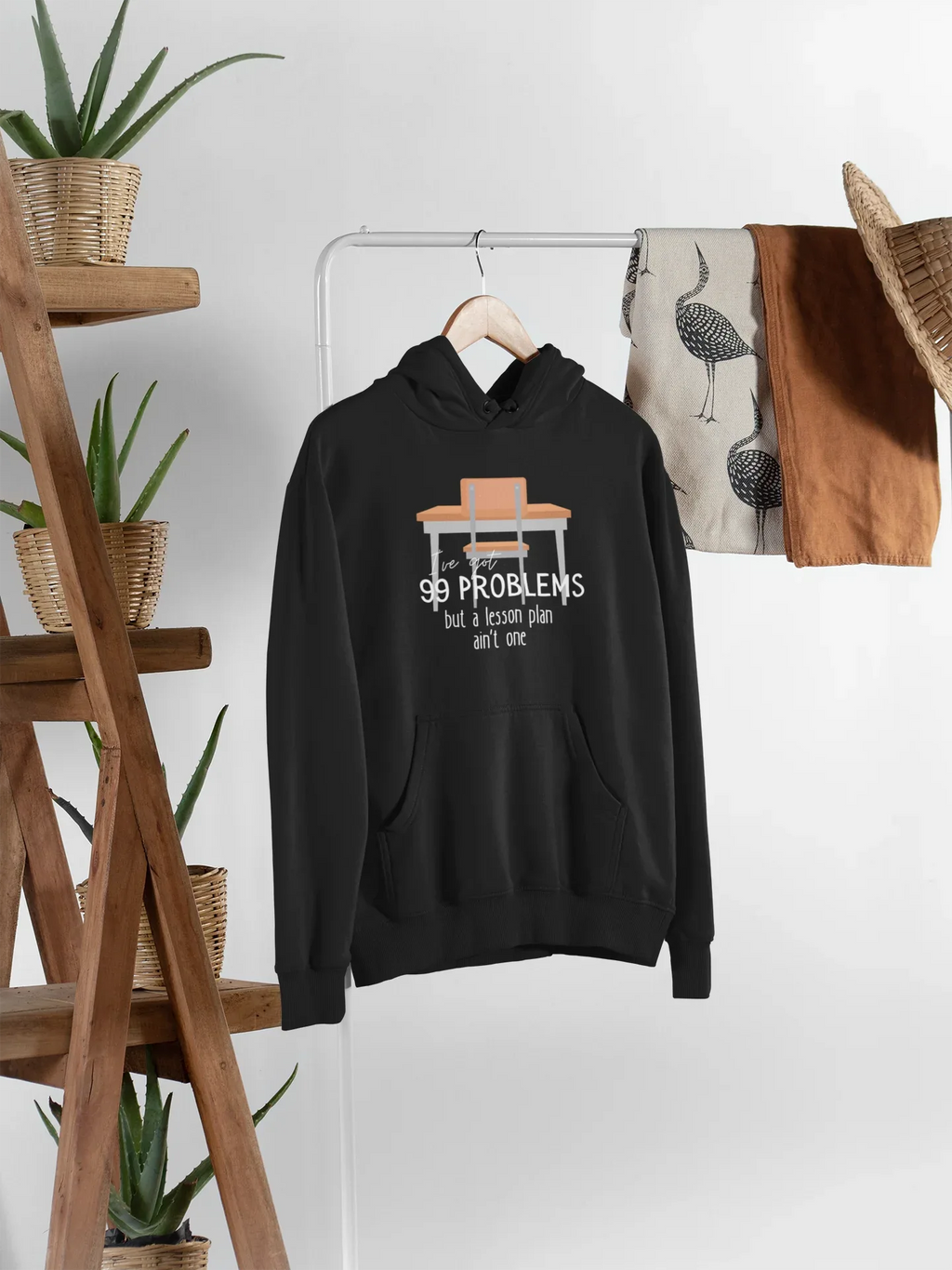 Black unisex hoodie on hanger with kangaroo pocket and drawstring hood; '99 problems' print.