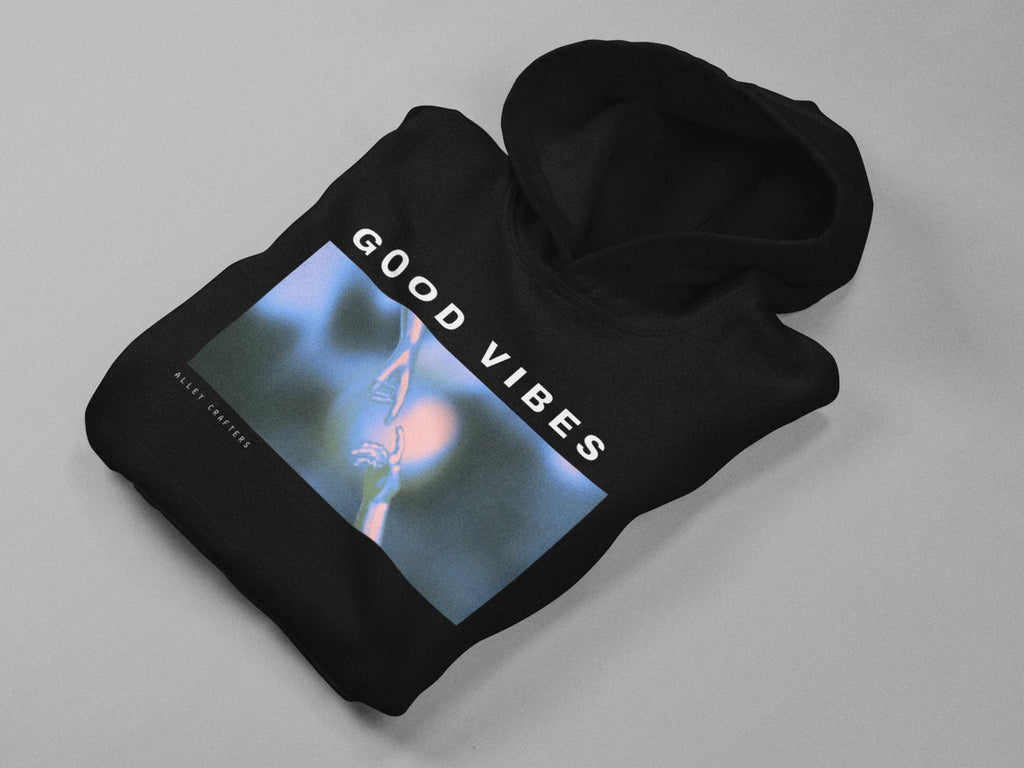 Black unisex hoodie folded, showing 'GOOD VIBES' front graphic