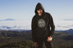Black pullover hoodie with hood and circular “Adventure” logo on the chest.