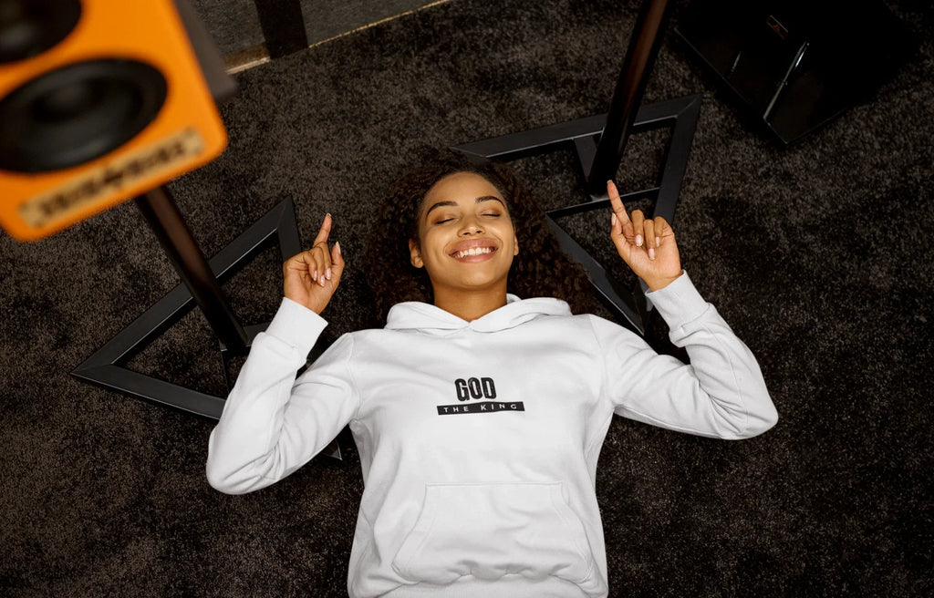 White hooded sweatshirt with front pocket and 'GOD THE KING' chest graphic.