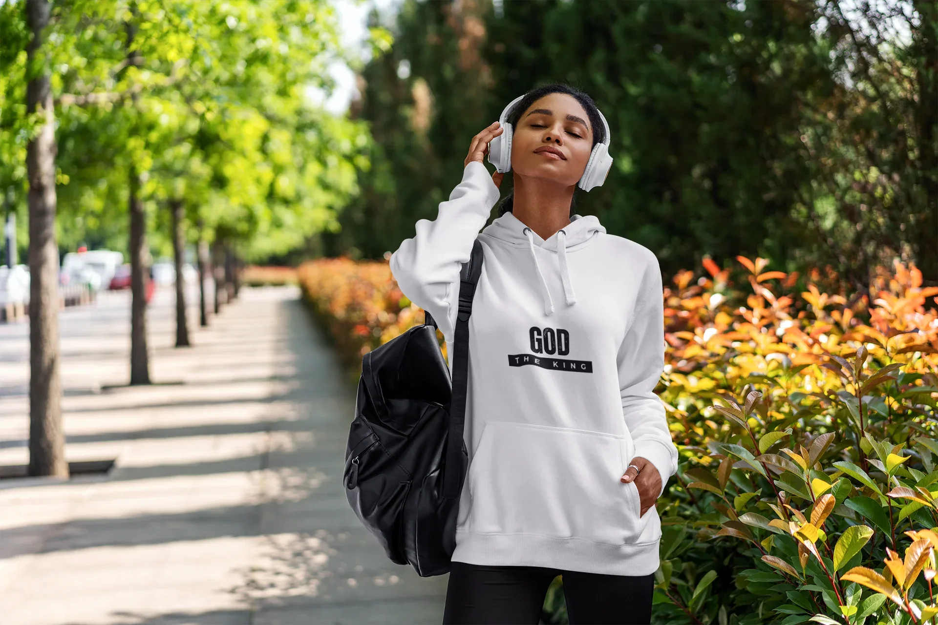 White hooded sweatshirt with kangaroo pocket, drawstring hood, and chest 'GOD THE KING' logo.