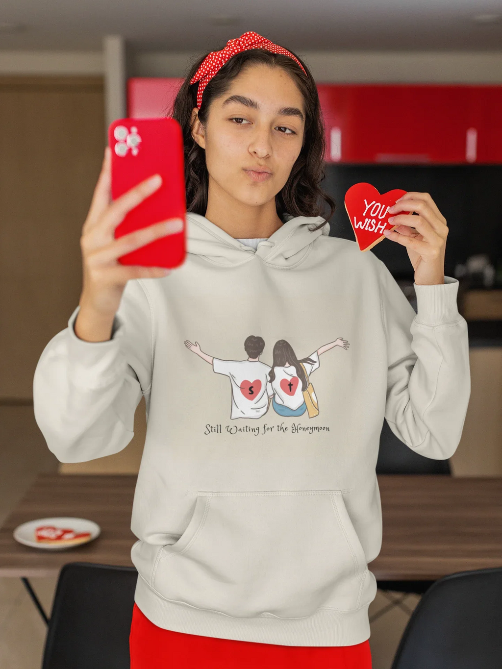 White pullover hoodie with drawstring hood and couple graphic on chest