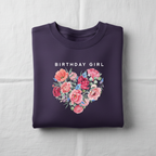 Purple crewneck sweatshirt with floral heart graphic and "BIRTHDAY GIRL" text