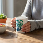 White mug with "Find Your Zen" lettering, held in hands with cozy sweater