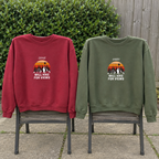 Red and military-green Will Hike for Views sweatshirts on a patio