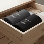 Dark gray crew-neck T-shirt stack in wooden drawer, chest shows “Slow Progress”