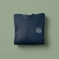 Dark blue folded hoodie with front pocket and chest logo graphic.