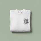 White folded hoodie with front pocket and chest logo graphic.