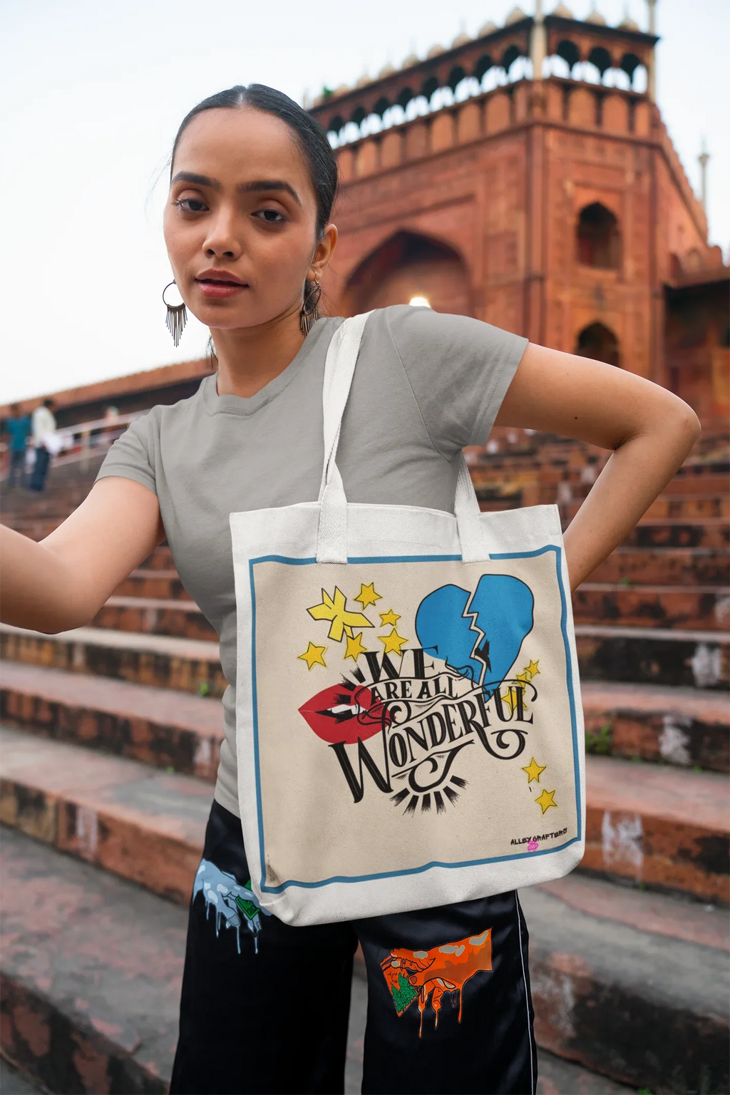 Light canvas tote bag with blue-bordered graphic and black shoulder straps
