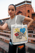 Light canvas tote bag with blue-bordered graphic and black shoulder straps