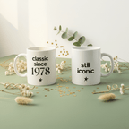 Two white ceramic coffee mugs: “classic since 1978” on left and “still iconic” on right
