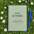 Sage green notebook laid on grass
