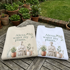 Two crewneck sweatshirts on a wooden bench: sand and white, each with plant-themed slogan
