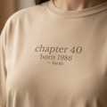 Cream T-shirt with “chapter 40 born 1986” and “Sarah” text