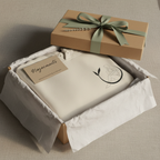 Cream unisex yoga hoodie folded in gift box with bow and label