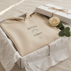 Beige hoodie with drawstring hood, small chest slogan graphic, laid in gift box