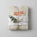 Light cream crewneck sweatshirt folded with ribbon and Take a Deep Breath floral print