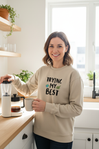 Sand sweatshirt on standing woman, 'TRYING MY BEST' quote with globe and leaves