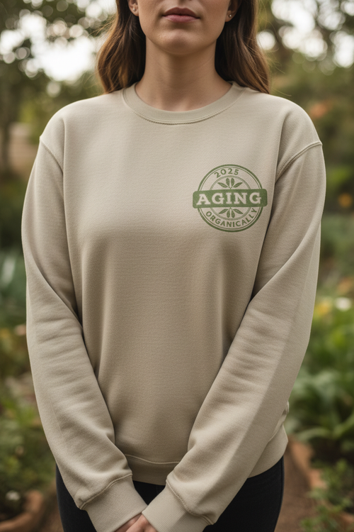 Cream sweatshirt with long sleeves, crew neck, and small green circular logo on chest.