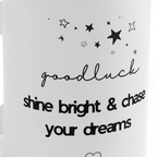 Close-up of white mug with stars and “goodluck shine bright & chase your dreams”